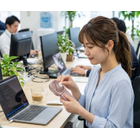 女性がアロマシールをハンディファンに貼っている画像.トリミング.jpg